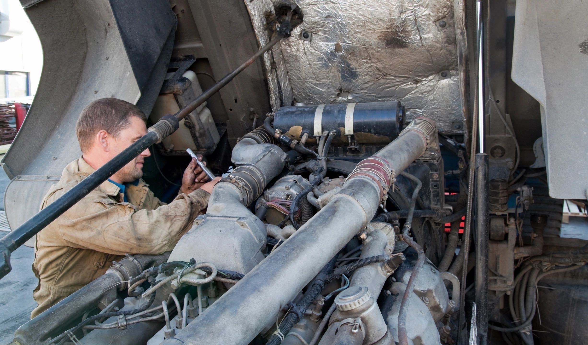 A man working on an engine in the middle of a truck.